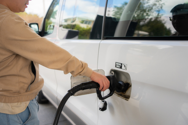During the oil crisis, a driver pumps diesel fuel at a gas station.