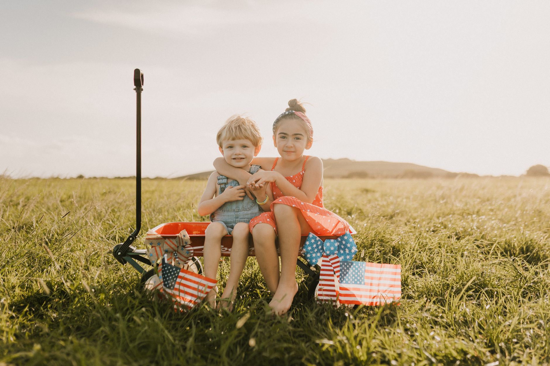 children enjoying summer in a field with flags