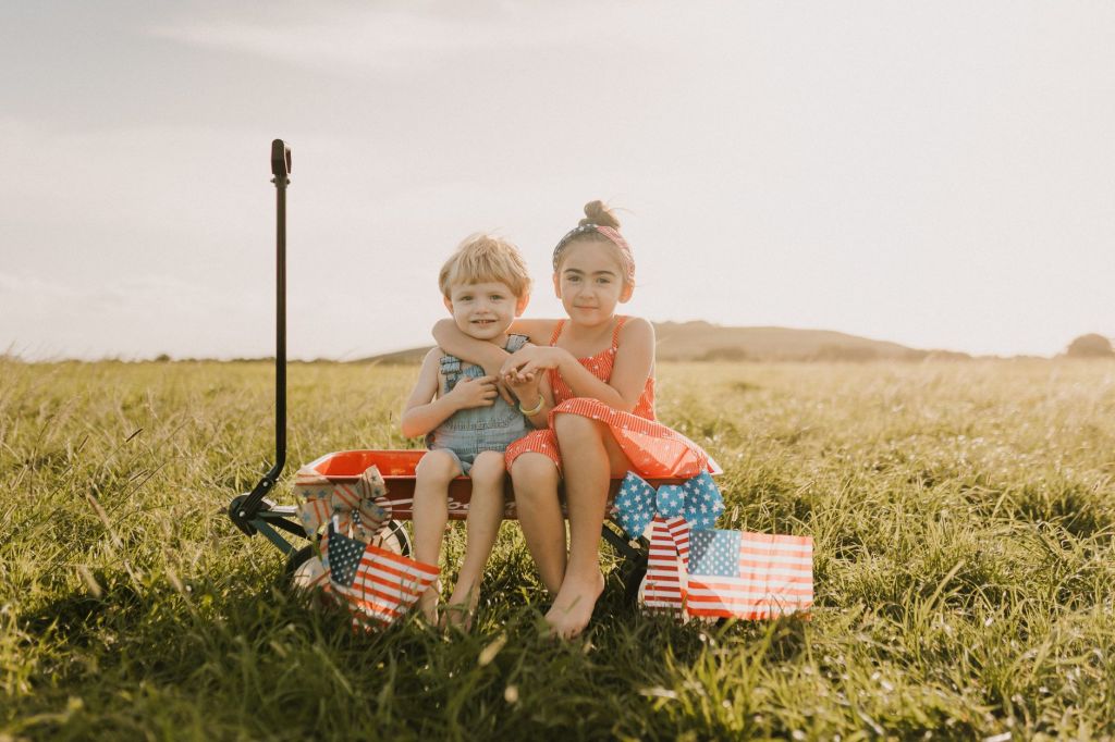 children enjoying summer in a field with flags