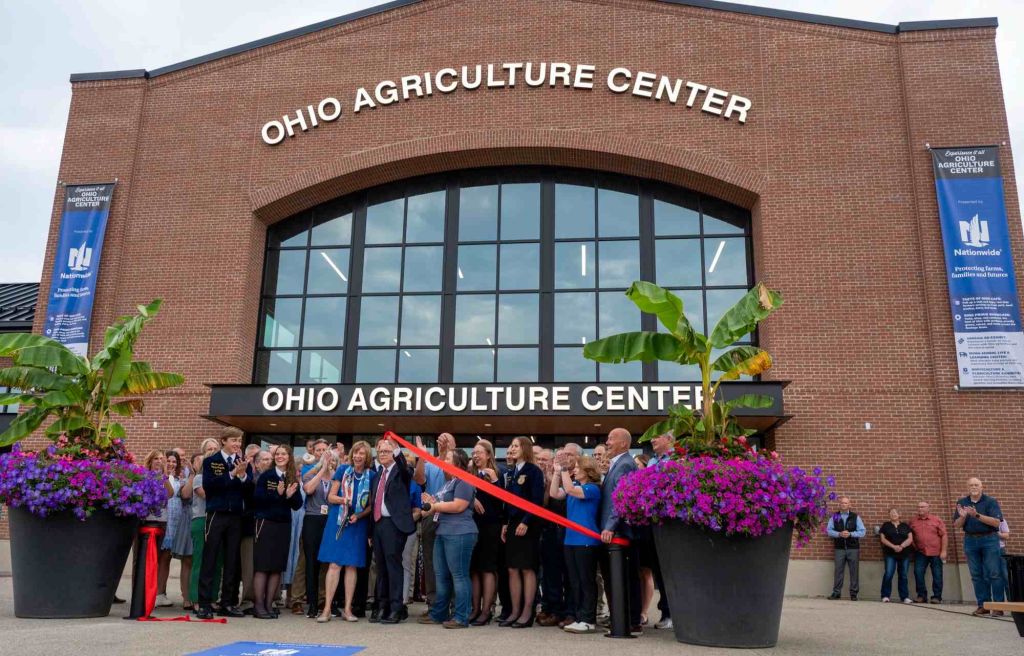 Ohio Agriculture Center building with group of people gathered for a ribbon-cutting ceremony in front of the entrance.